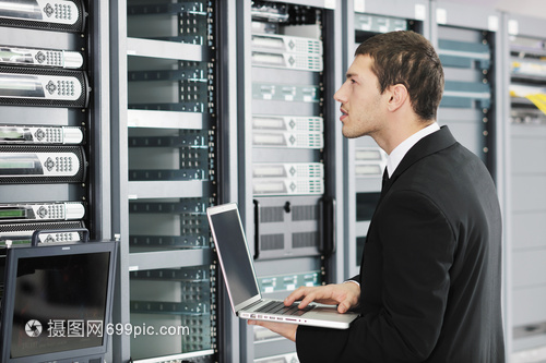 輕的IT工程師商務人員與薄的現代鋁筆記本電腦 網絡服務器機房中的高效協作